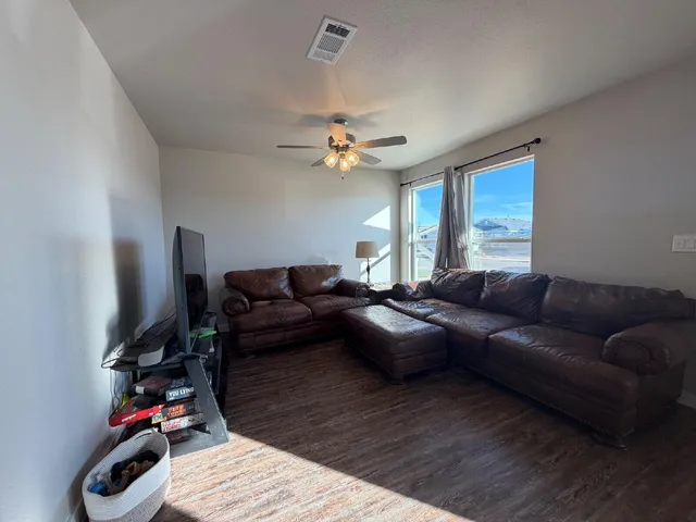 a living room with furniture a ceiling fan and a rug