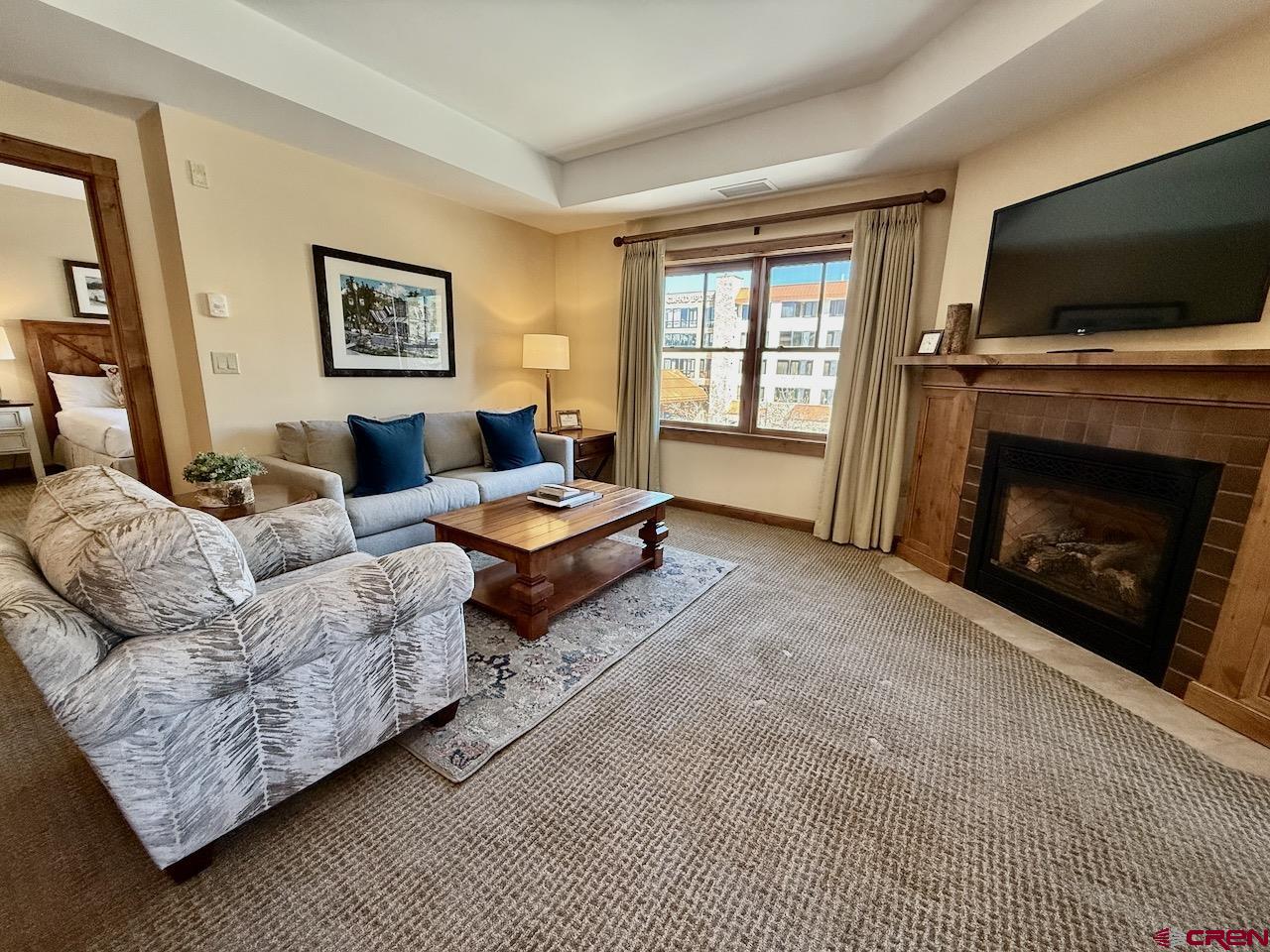 620 Gothic Road, Unit 206 Crested Butte, CO 81225 - Photo 12 of 41 a living room with furniture a flat screen tv and a fireplace