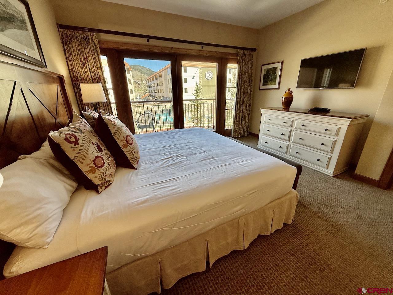 620 Gothic Road, Unit 206 Crested Butte, CO 81225 - Photo 21 of 41 a bedroom with a bed and a large window
