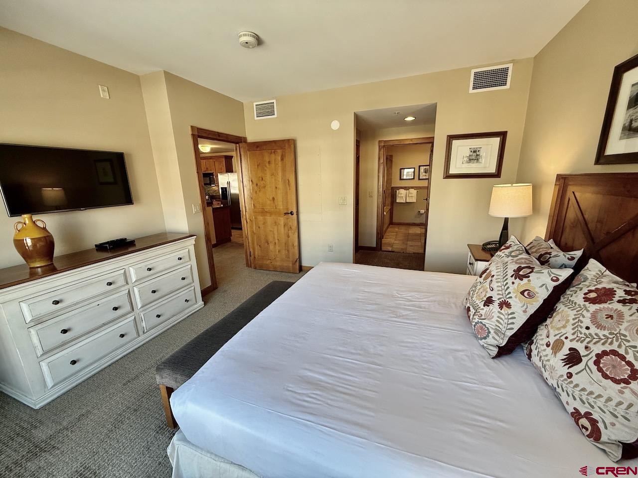 620 Gothic Road, Unit 206 Crested Butte, CO 81225 - Photo 22 of 41 a bedroom with a bed and a flat tv screen on dresser