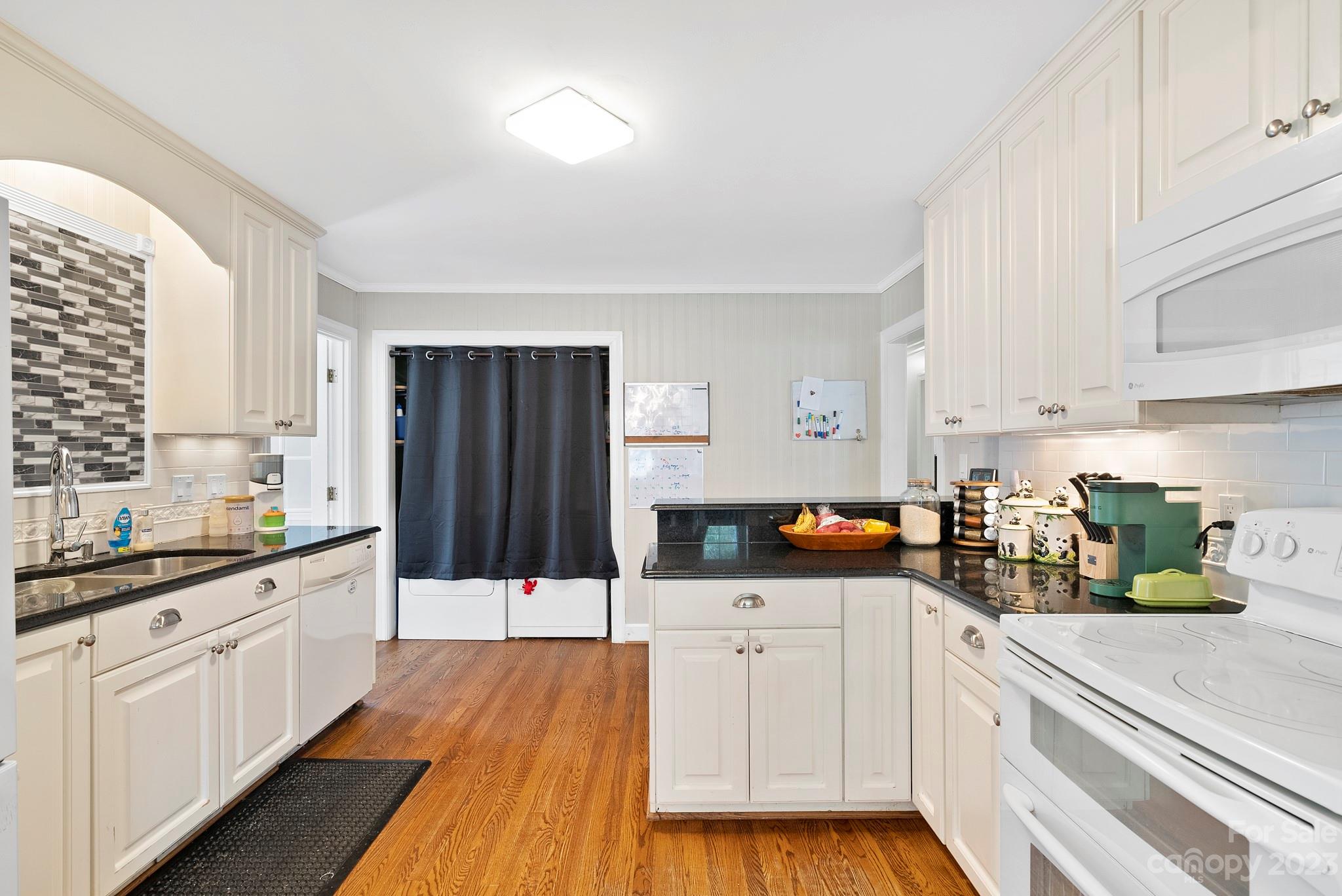 6501 Wynbrook Way Raleigh, NC 27612 - Photo 13 of 30 a kitchen with stainless steel appliances a sink dishwasher stove refrigerator and cabinets with wooden floor