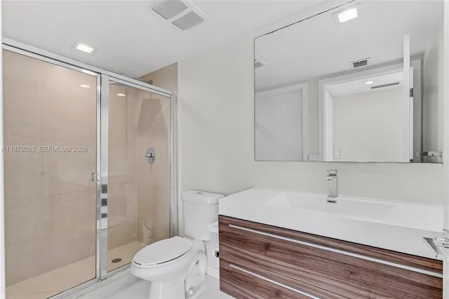 a spacious bathroom with a glass shower door and sink