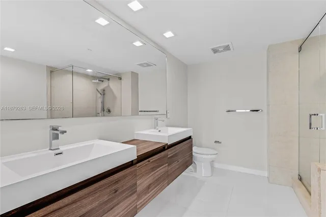 a bathroom with a tub shower sink and mirror