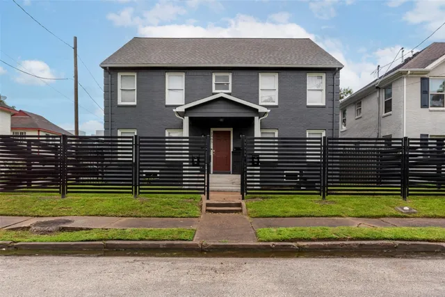 a front view of a house with a garden and plants