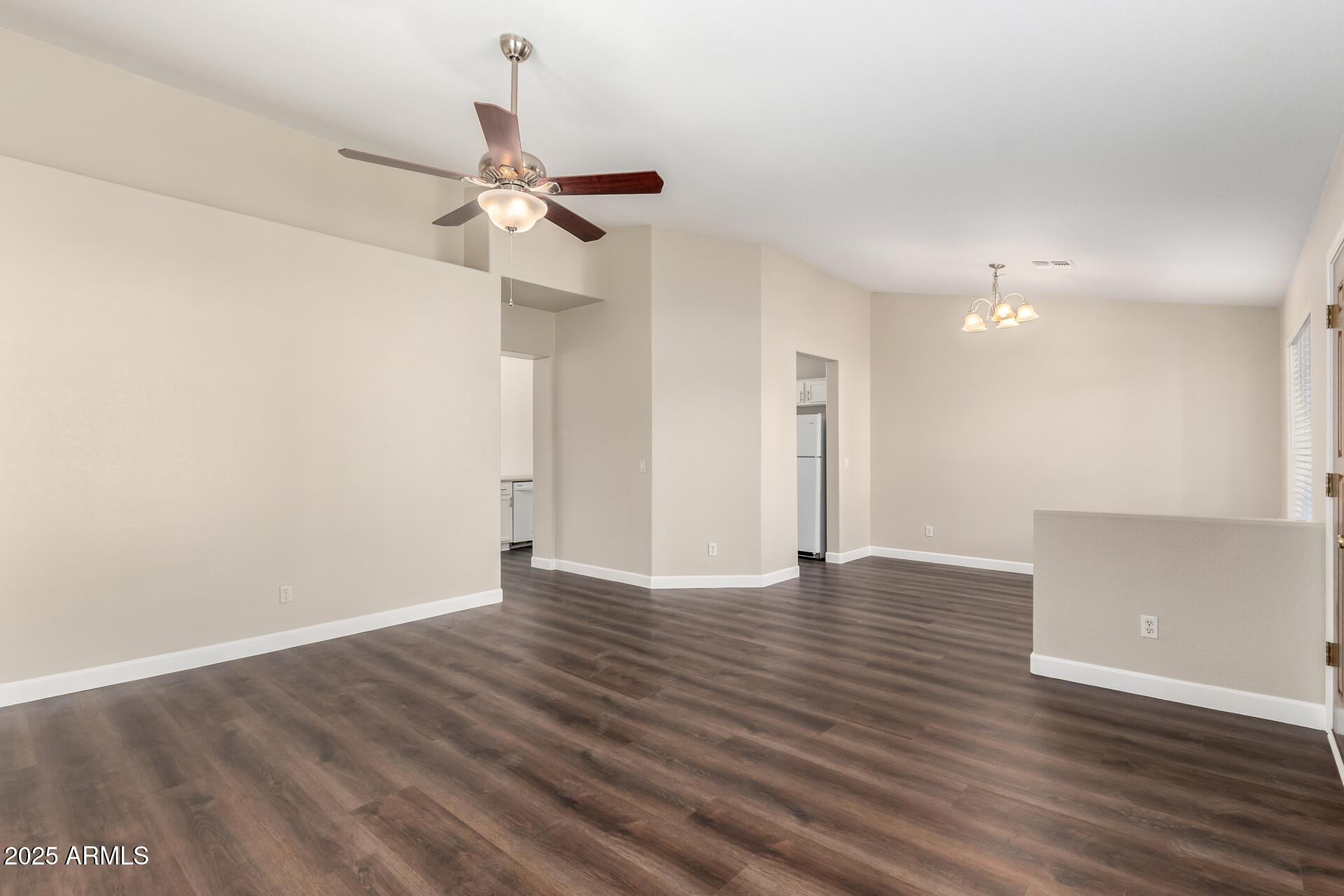 501 West Mesquite Street Gilbert, AZ 85233 - Photo 2 of 24 a view of an empty room with wooden floor and a ceiling fan