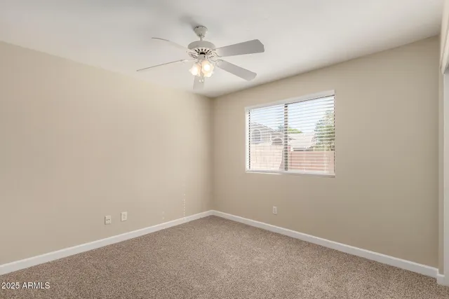 an empty room with a window and a fan