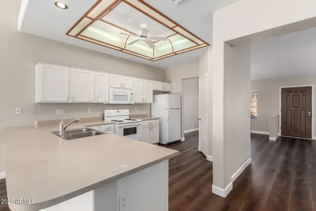 a kitchen that has a lot of cabinets and wooden floor