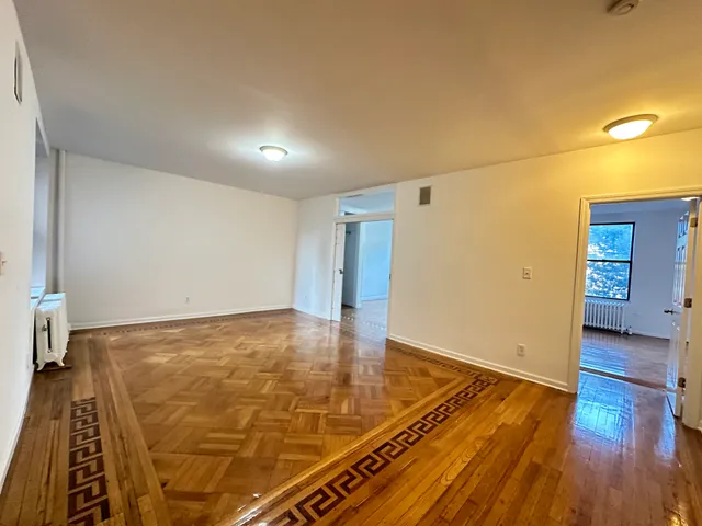 a view of an empty room with wooden floor