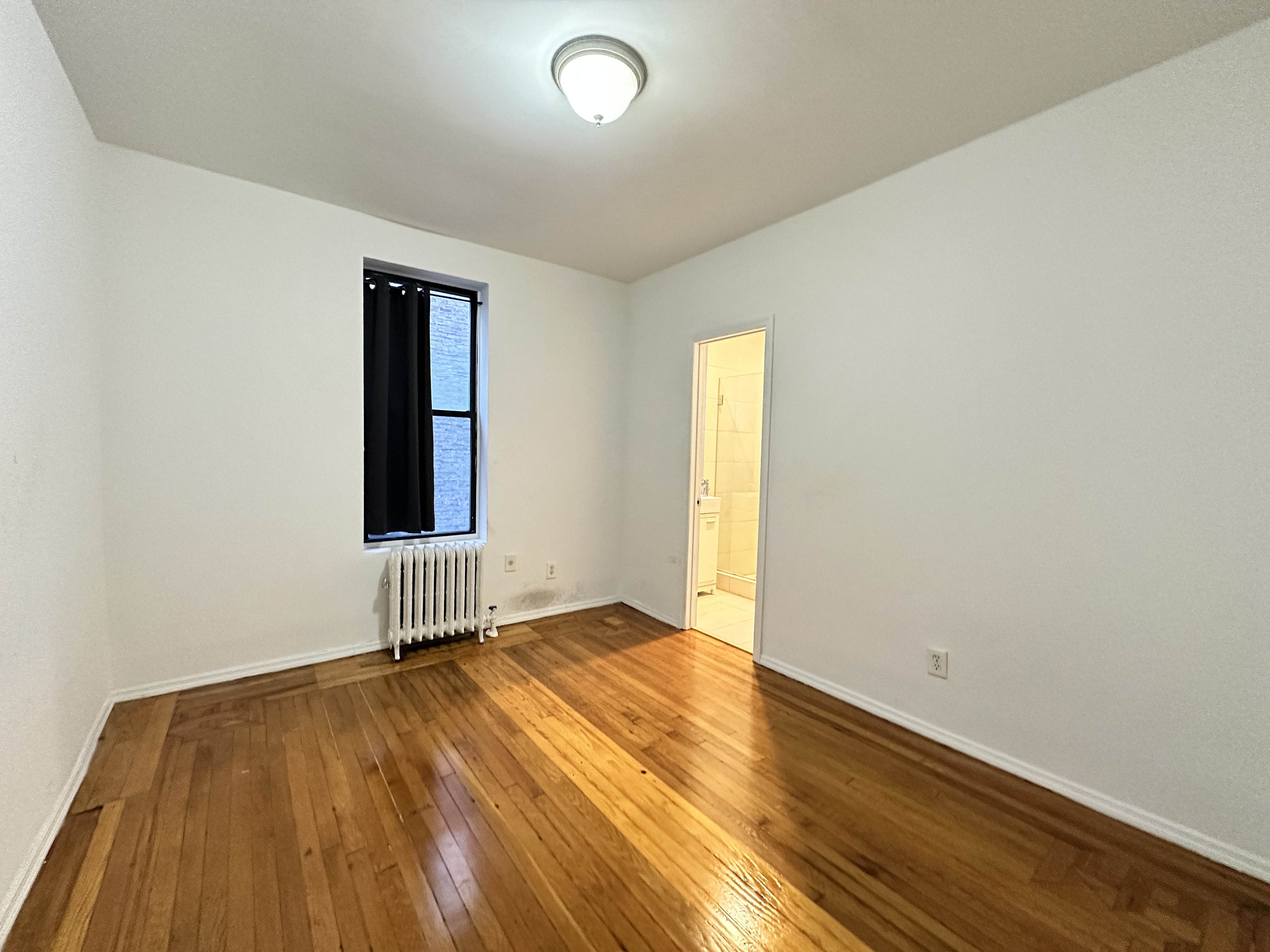 601 West 149th Street, Unit 35 Manhattan, NY 10031 - Photo 4 of 9 an empty room with wooden floor and windows