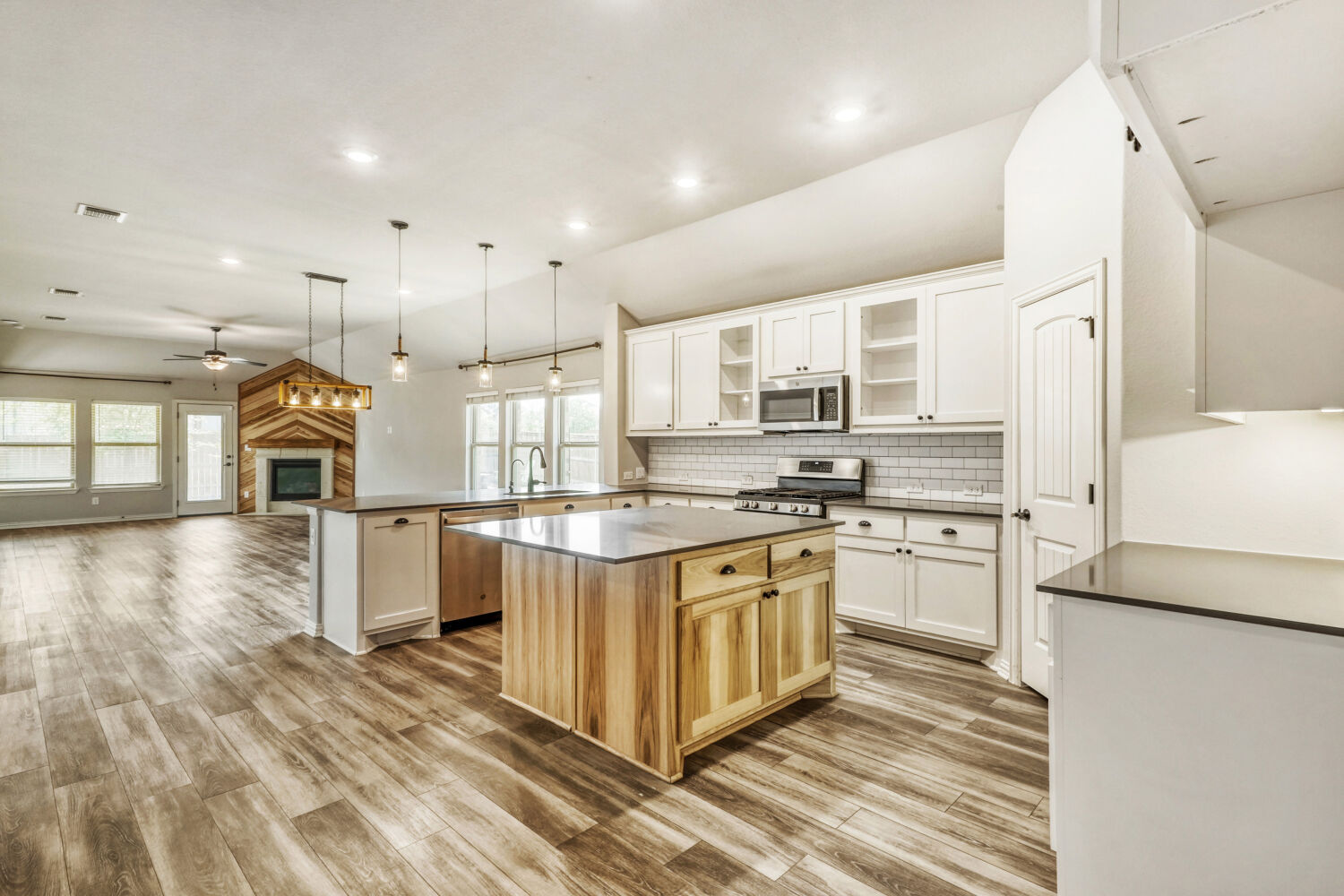 426 Cold Riv Run Kyle, TX 78640 - Photo 24 of 24 Light, bright kitchen with open floor plan, glass insert cabinets, stainless steel appliances, gas range, and a kitchen island