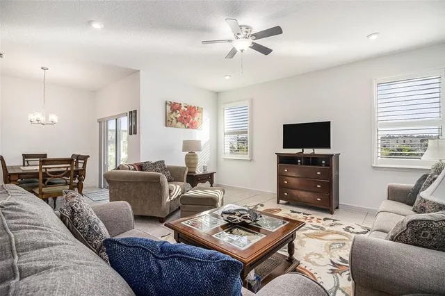 a living room with furniture a flat screen tv and a window