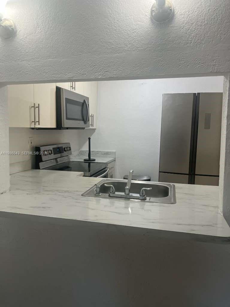 a kitchen with a sink and a stove top oven