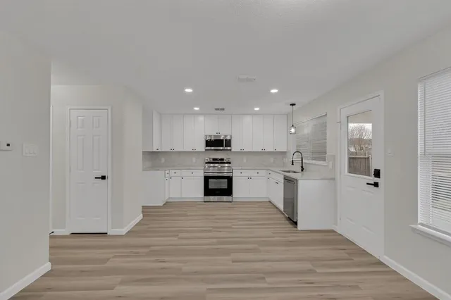 a view of kitchen with wooden floor and electronic appliances