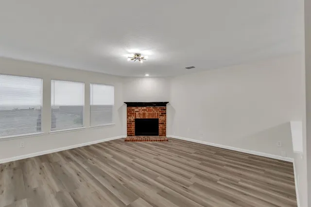 wooden floor in an empty room with a fireplace