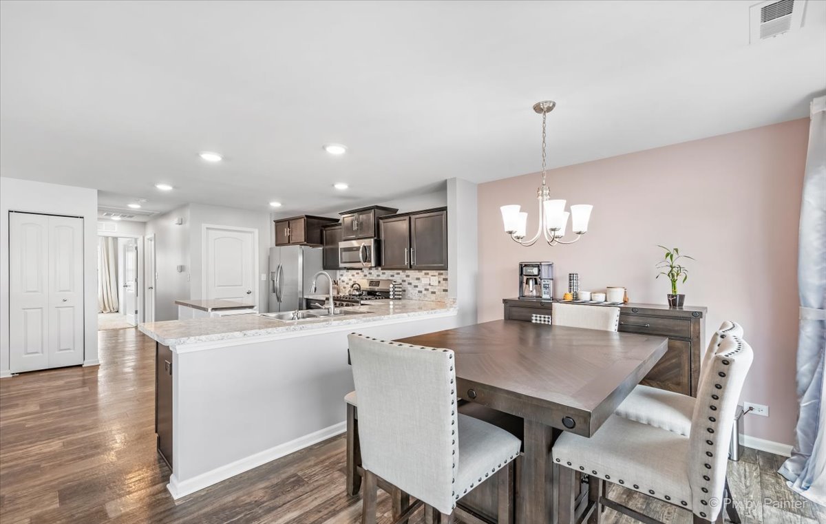 2340 Upland Road Pingree Grove, IL 60140 - Photo 3 of 29 a dining room with kitchen island a table and chairs