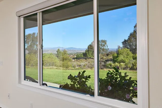 a view of a grassy field with trees in the background