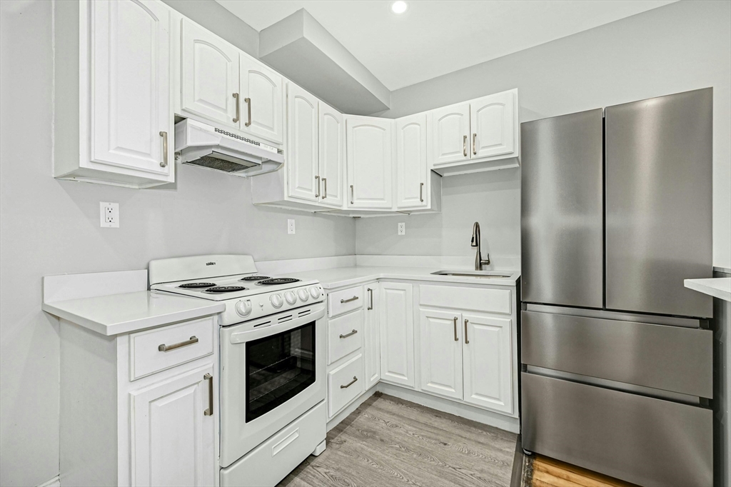 34 William Street Worcester, MA 01609 - Photo 25 of 41 a kitchen with cabinets stainless steel appliances wooden floor and a window
