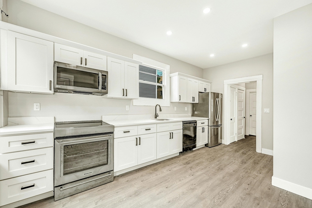 34 William Street Worcester, MA 01609 - Photo 9 of 41 a kitchen with granite countertop white cabinets stainless steel appliances and sink