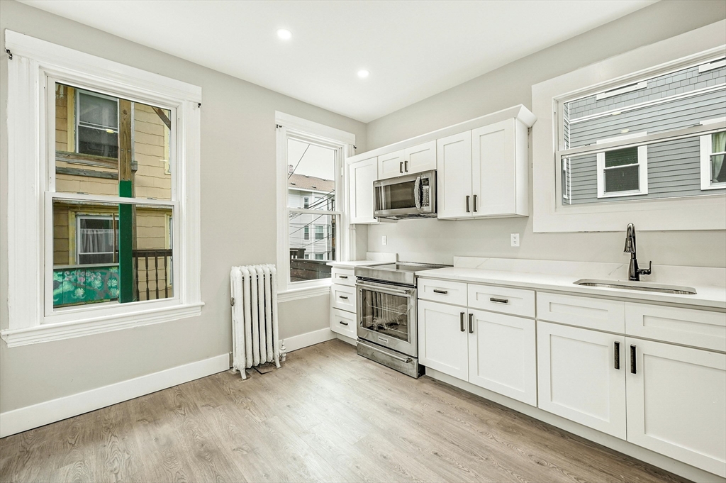 34 William Street Worcester, MA 01609 - Photo 10 of 41 a kitchen with white cabinets and wooden floor