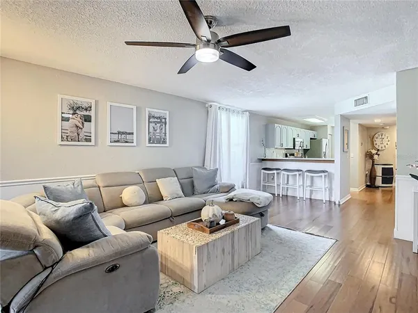 a living room with furniture and a wooden floor