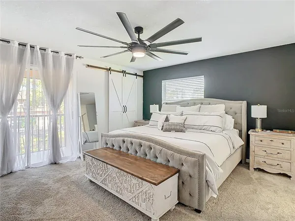 a bedroom with a bed mirror and window