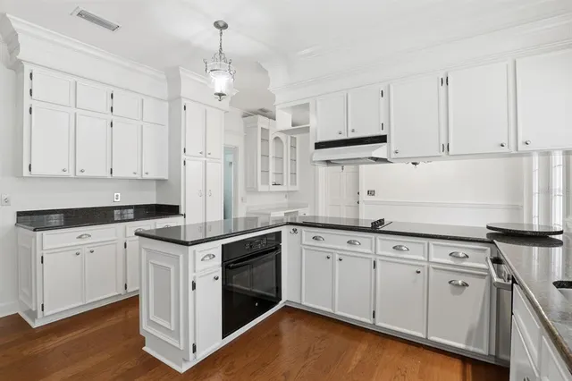 a kitchen with stainless steel appliances granite countertop a sink stove and white cabinets