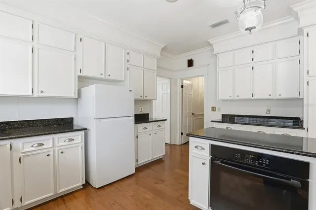 a kitchen with white cabinets and white appliances
