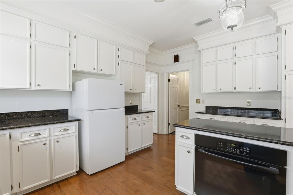 6307 Southwest 35th Way Gainesville, FL 32608 - Photo 12 of 32 a kitchen with white cabinets and white appliances