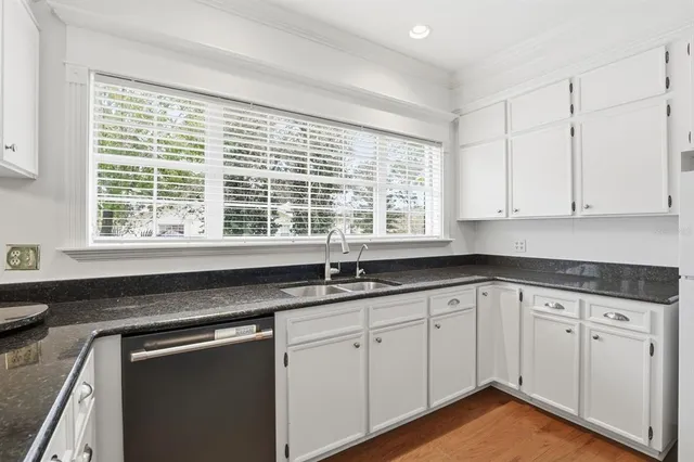 a kitchen with granite countertop white cabinets and white appliances