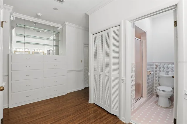 a view of bathroom with a toilet a sink and wooden floor