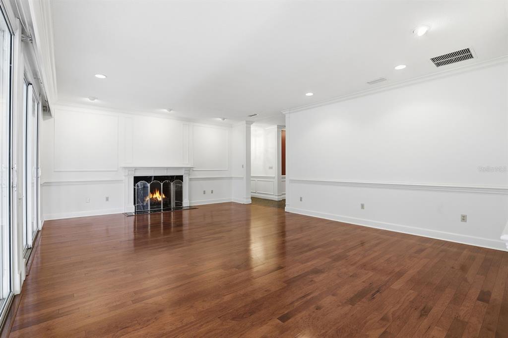 6307 Southwest 35th Way Gainesville, FL 32608 - Photo 5 of 32 an empty room with wooden floor and a view of kitchen