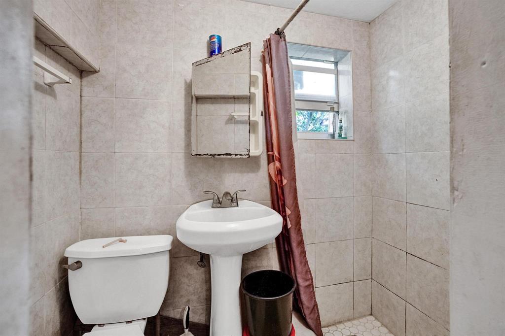 Allapattah Miami, FL 33142 - Photo 53 of 58 a bathroom with a toilet sink and mirror