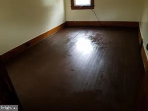 a view of a room with wooden floor and a window