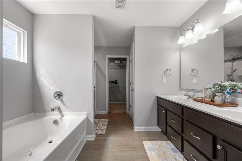 4607 Underwood Walk Powder Springs, GA 30127 - Photo 18 of 31 a bathroom with a tub sink and mirror
