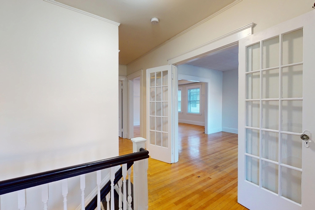 a view of a hallway with wooden floor and entryway