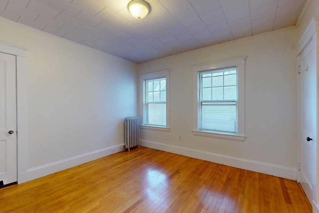 12 Park Street, Unit 2 Waltham, MA 02453 - Photo 14 of 20 an empty room with wooden floor and windows