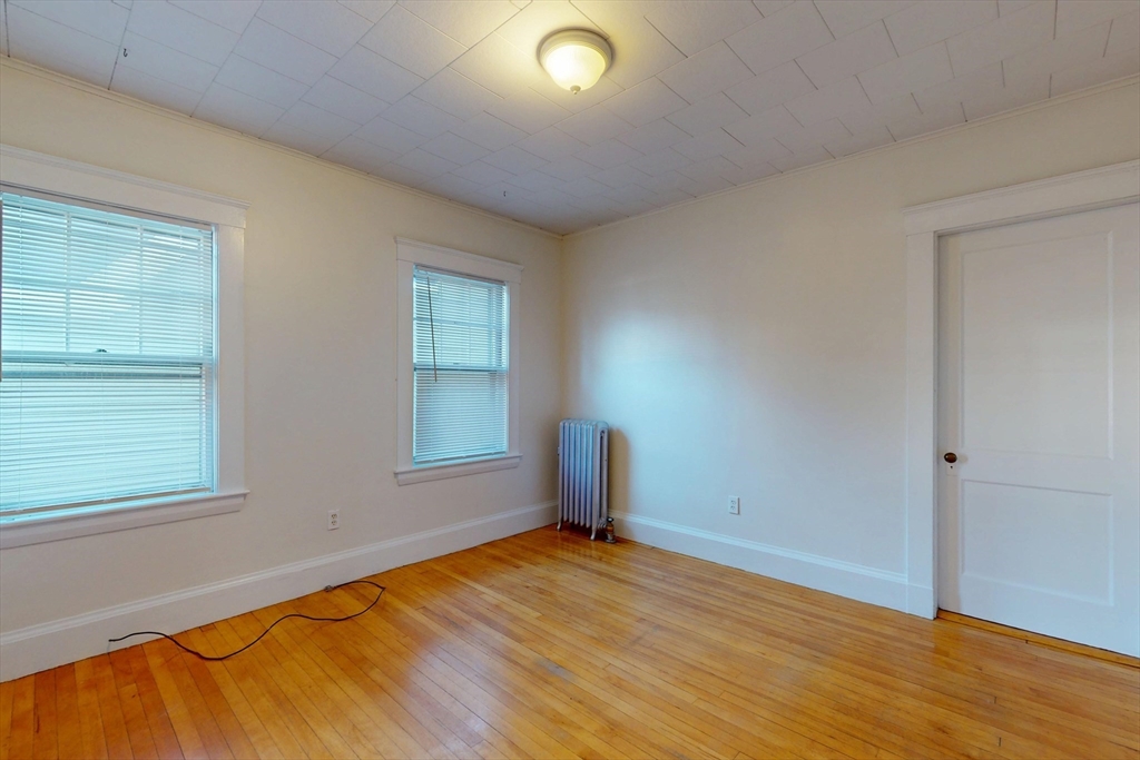 12 Park Street, Unit 2 Waltham, MA 02453 - Photo 15 of 20 an empty room with wooden floor and windows