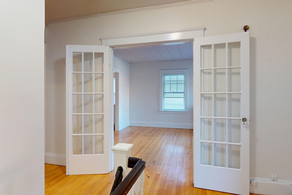 12 Park Street, Unit 2 Waltham, MA 02453 - Photo 2 of 20 a view of an empty room with wooden floor and a window