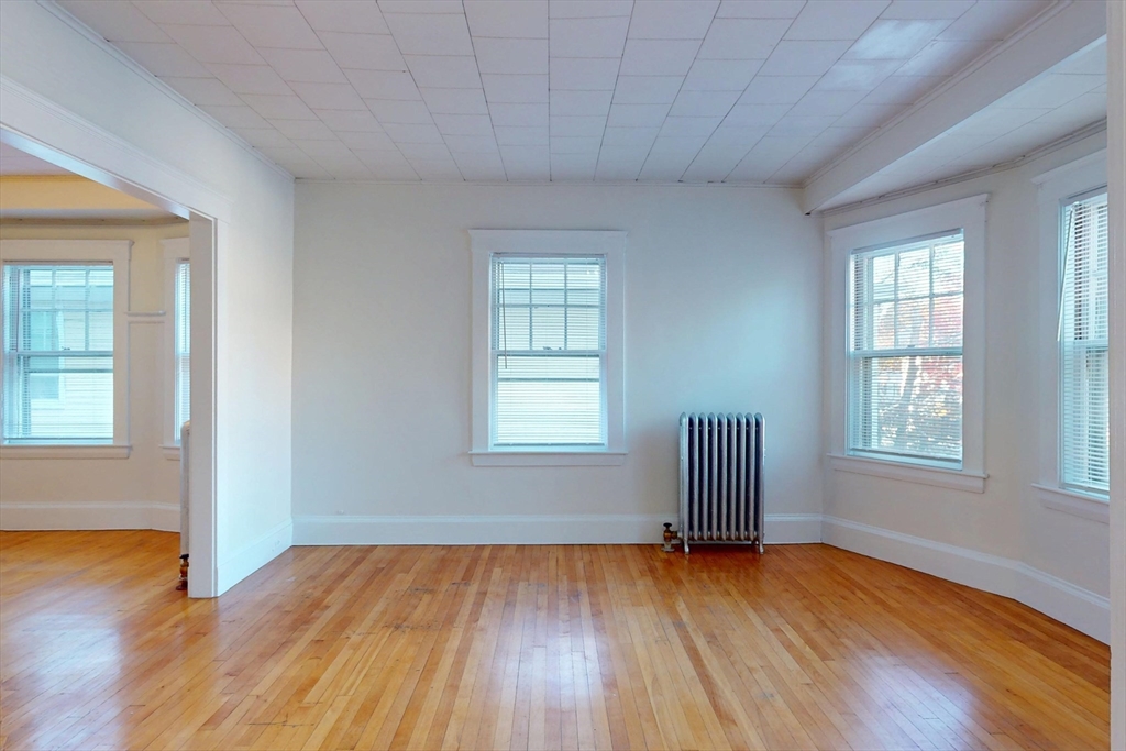 12 Park Street, Unit 2 Waltham, MA 02453 - Photo 3 of 20 an empty room with wooden floor and windows
