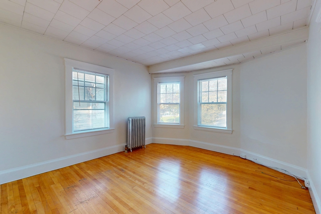 12 Park Street, Unit 2 Waltham, MA 02453 - Photo 4 of 20 a view of empty room with wooden floor and fan