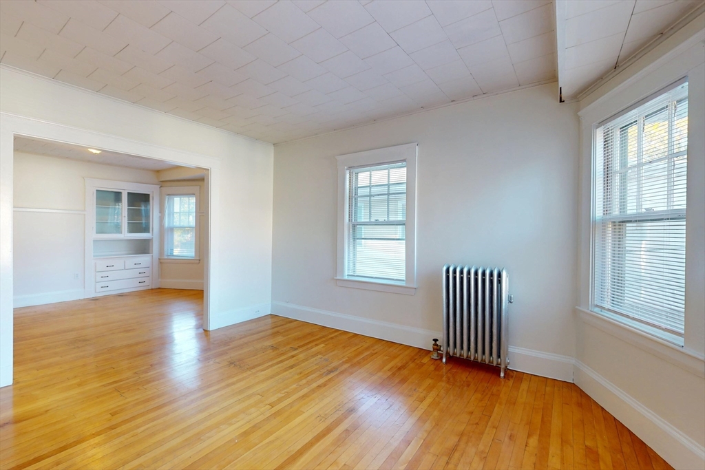 12 Park Street, Unit 2 Waltham, MA 02453 - Photo 5 of 20 a view of empty room with wooden floor and fan