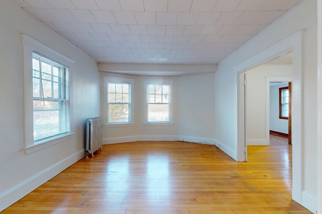 12 Park Street, Unit 2 Waltham, MA 02453 - Photo 6 of 20 a view of empty room with wooden floor and fan