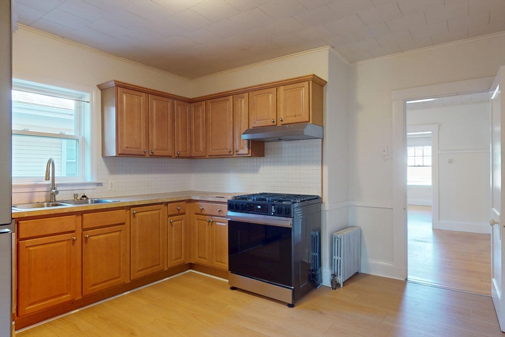12 Park Street, Unit 2 Waltham, MA 02453 - Photo 8 of 20 a kitchen with stainless steel appliances granite countertop a stove a sink and a refrigerator