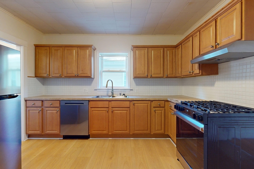 12 Park Street, Unit 2 Waltham, MA 02453 - Photo 9 of 20 a kitchen with stainless steel appliances granite countertop a stove a sink and a microwave