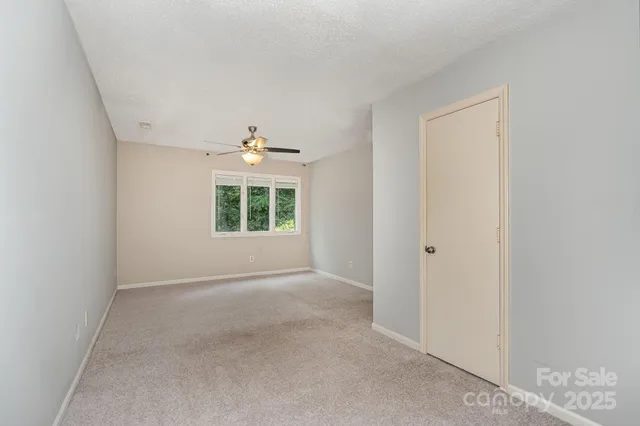 an empty room with windows and chandelier