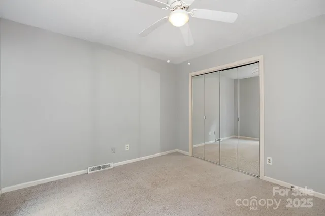 an empty room with a chandelier fan