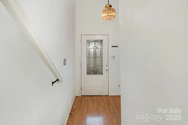a view of a hallway with wooden floor and entryway