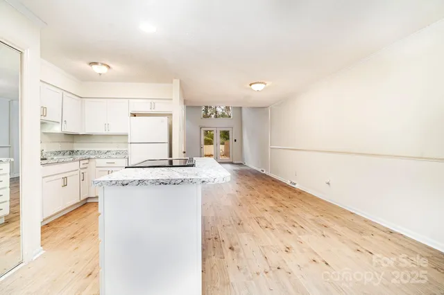 a kitchen with granite countertop a sink and white cabinets