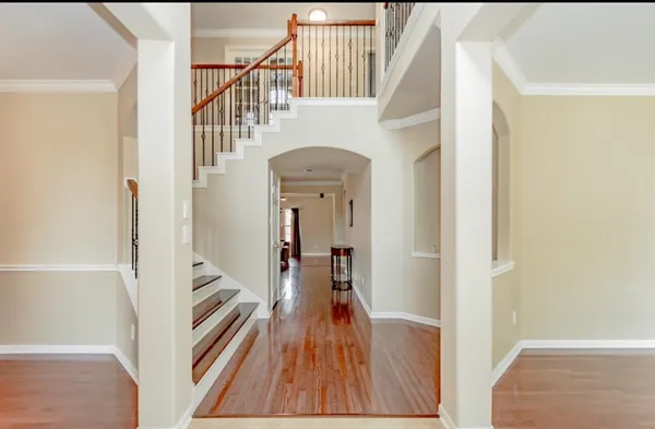 a view of a hallway with wooden floor and staircase