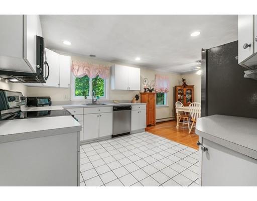 65 Grover Street Beverly, MA 01915 - Photo 12 of 33 a kitchen with stainless steel appliances kitchen island granite countertop a sink a stove a refrigerator cabinets and a dining table